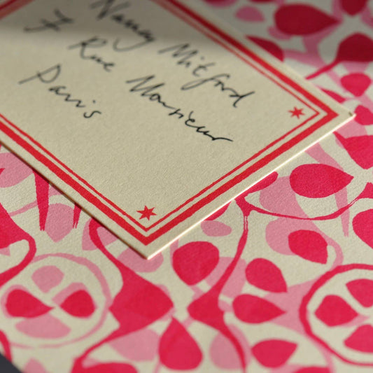 Note with text on a pink and red patterned background