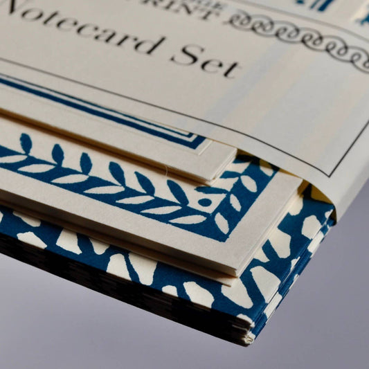 Stack of blue and white patterned cards with a visible brand name on a gray background