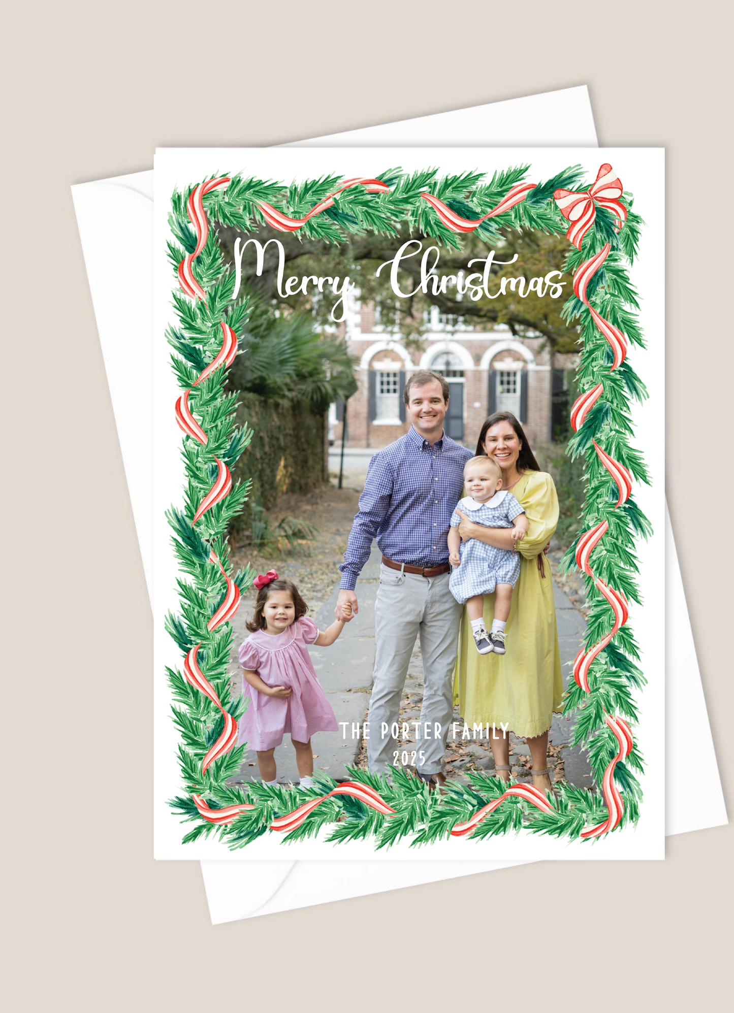 Christmas card with a family photo and festive border greenery with red and white ribbon