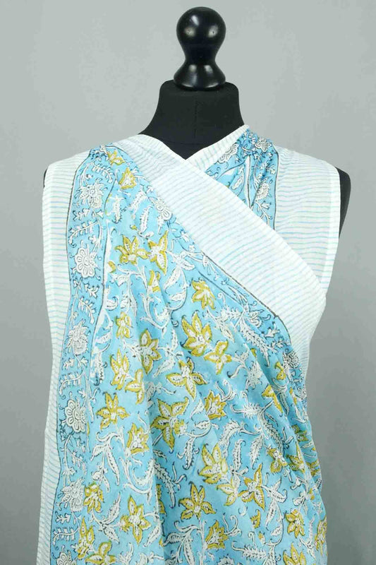 Mannequin wearing a white top with a blue floral patterned scarf draped over it against a gray background