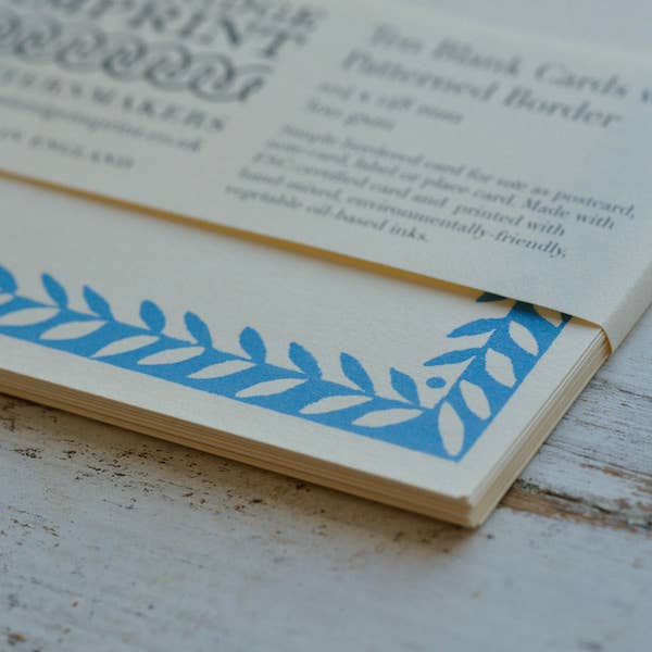 Card with blue leaf pattern on a wooden surface