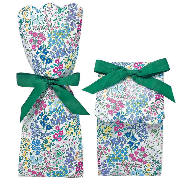 Two floral-patterned gift bags with green ribbons on a white background