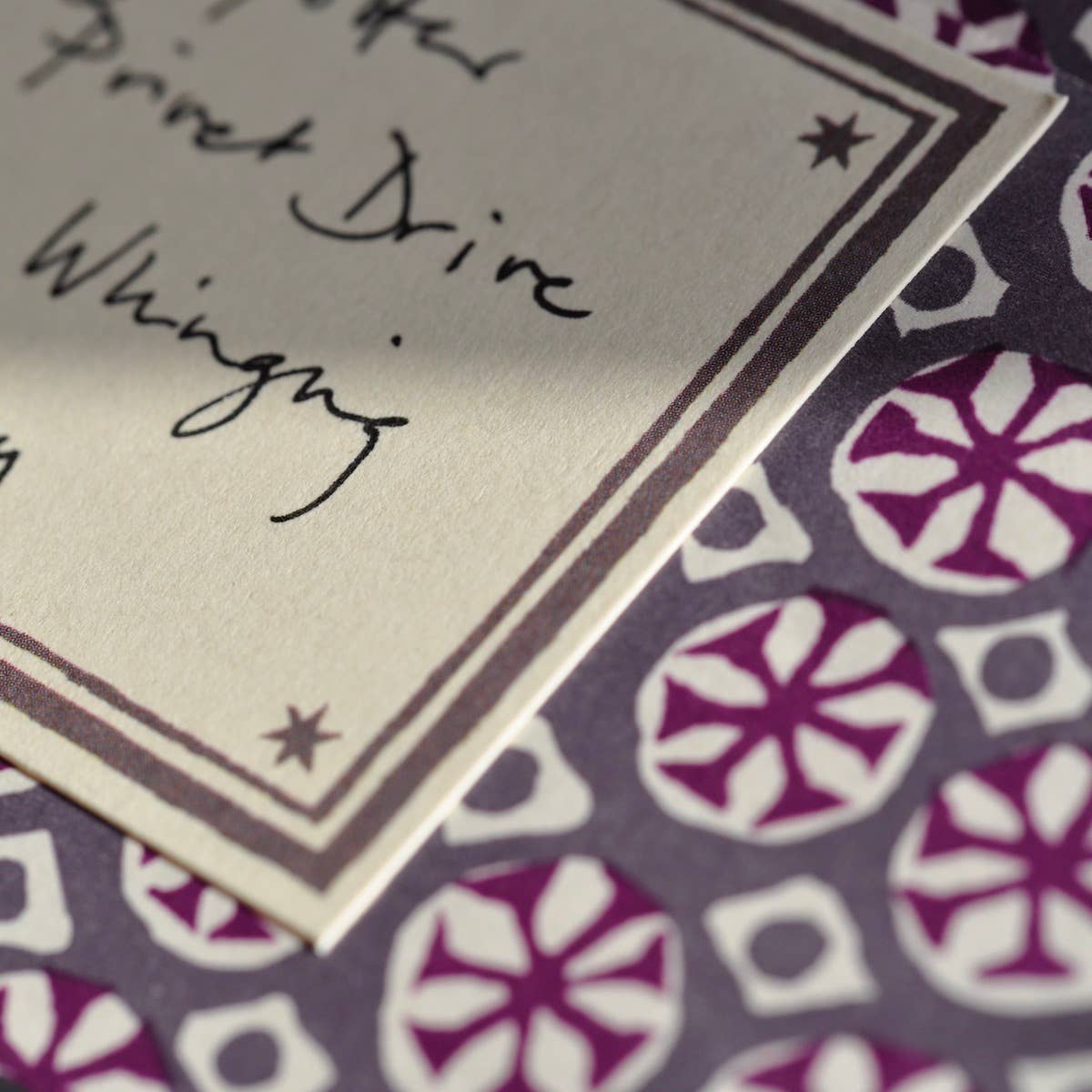 Notebook page with handwritten text on a patterned surface