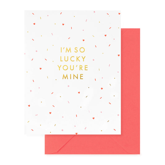 Greeting card with 'I'm so lucky you're mine' text and red envelope on white background