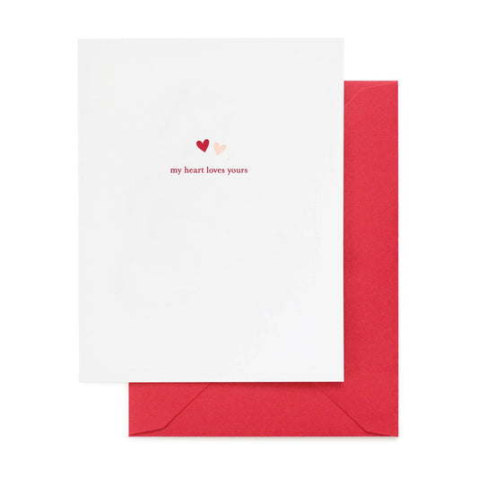White card with red hearts and text 'my heart loves yours' on a white background
