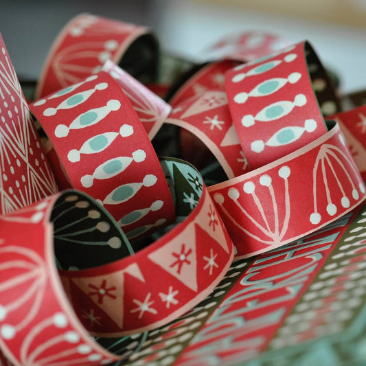 Red patterned paper strips on a textured surface