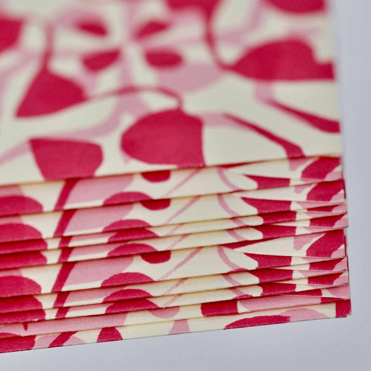 Stack of pink and white patterned paper on a light gray background