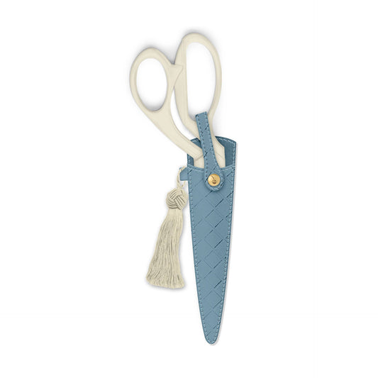 Scissors with a blue sheath and tassel on a white background