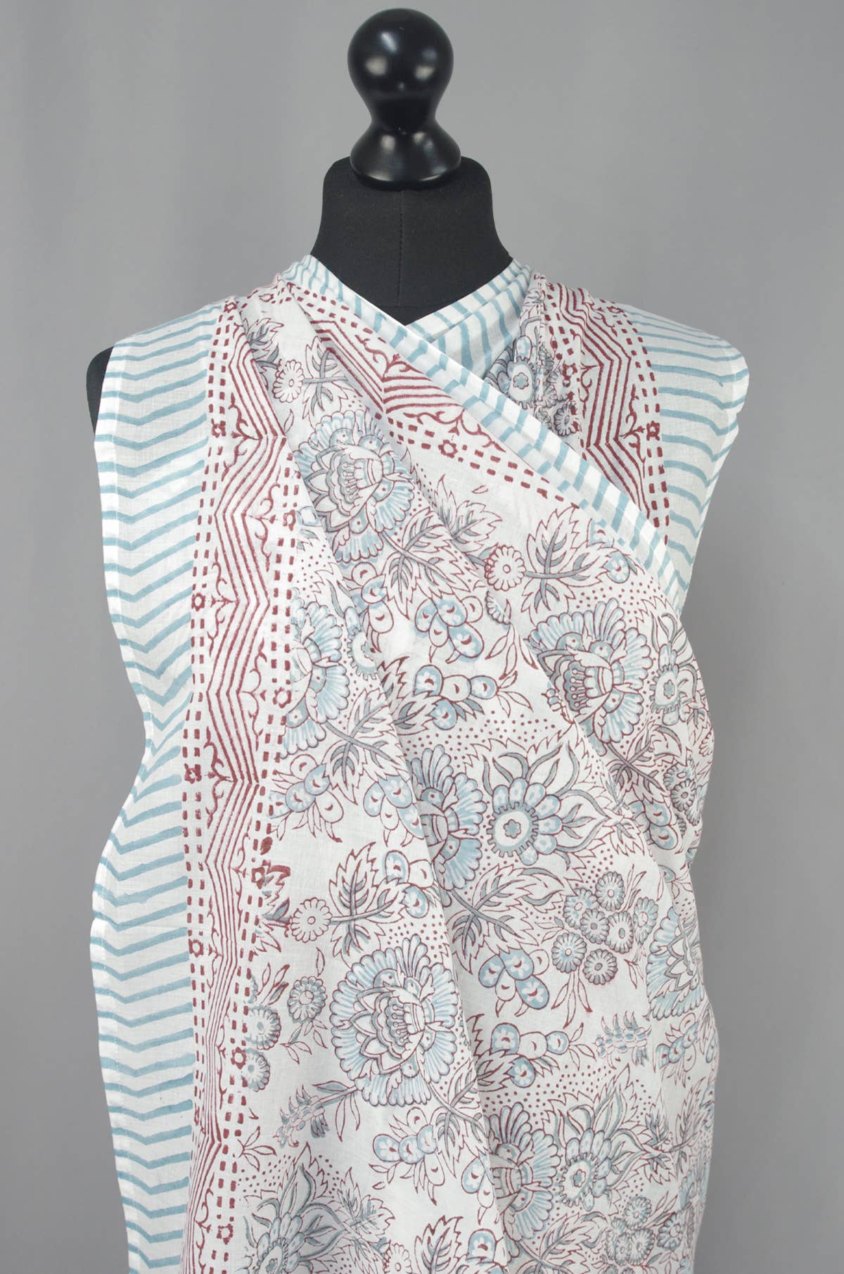 Sleeveless floral patterned top on a mannequin against a gray background