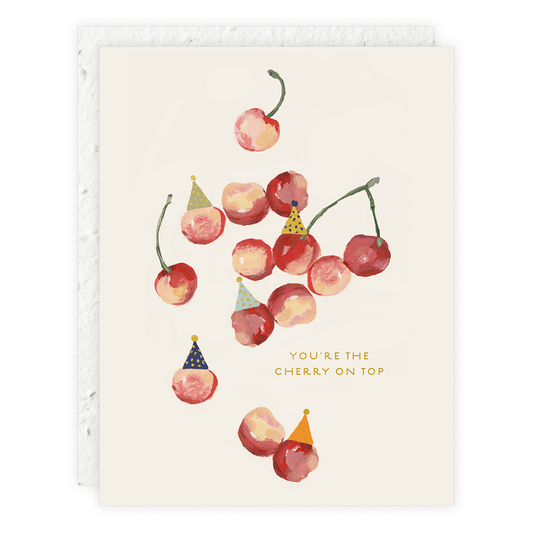 Card with cherries wearing party hats and text 'You're the cherry on top' on a beige background