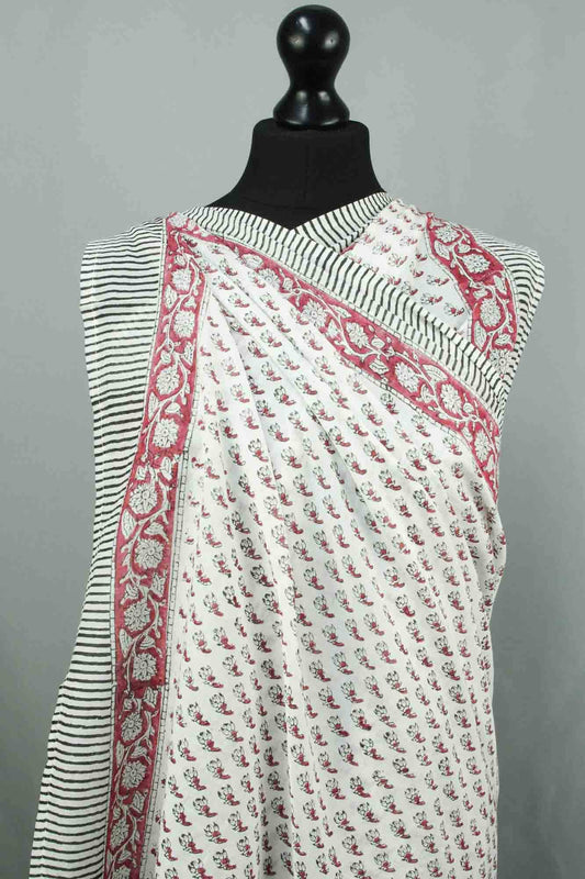 White saree with red floral patterns on a mannequin against a gray background