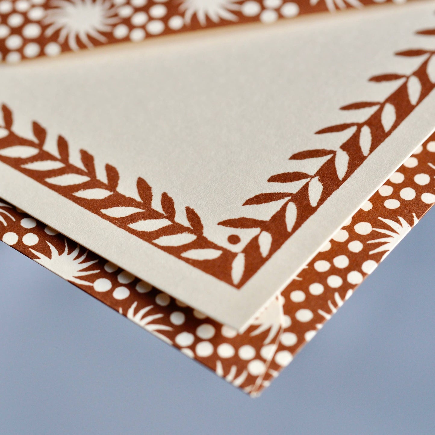 Set of patterned paper sheets with brown and white designs on a blue background