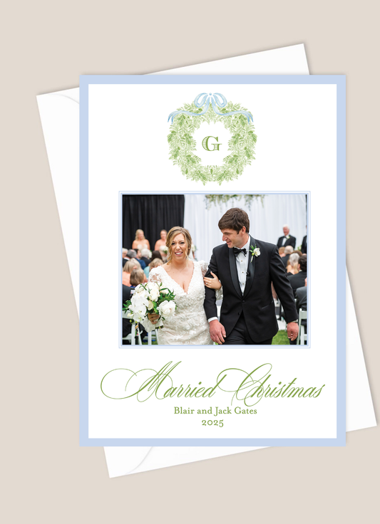 Christmas card with a photo of a bride and groom, text 'Married Christmas', and a decorative wreath with a blue border