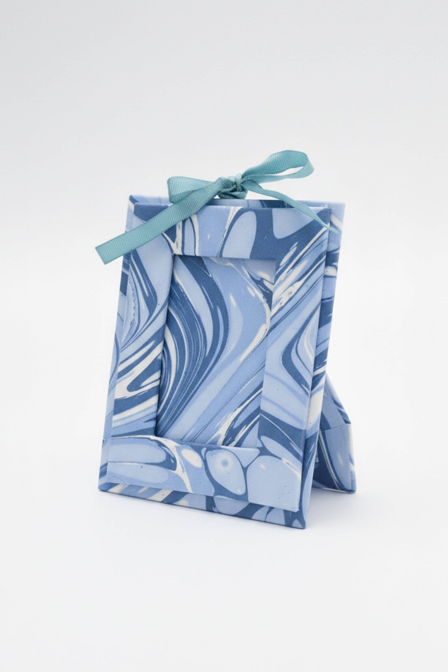 Blue marbled pouch with a ribbon on a white background