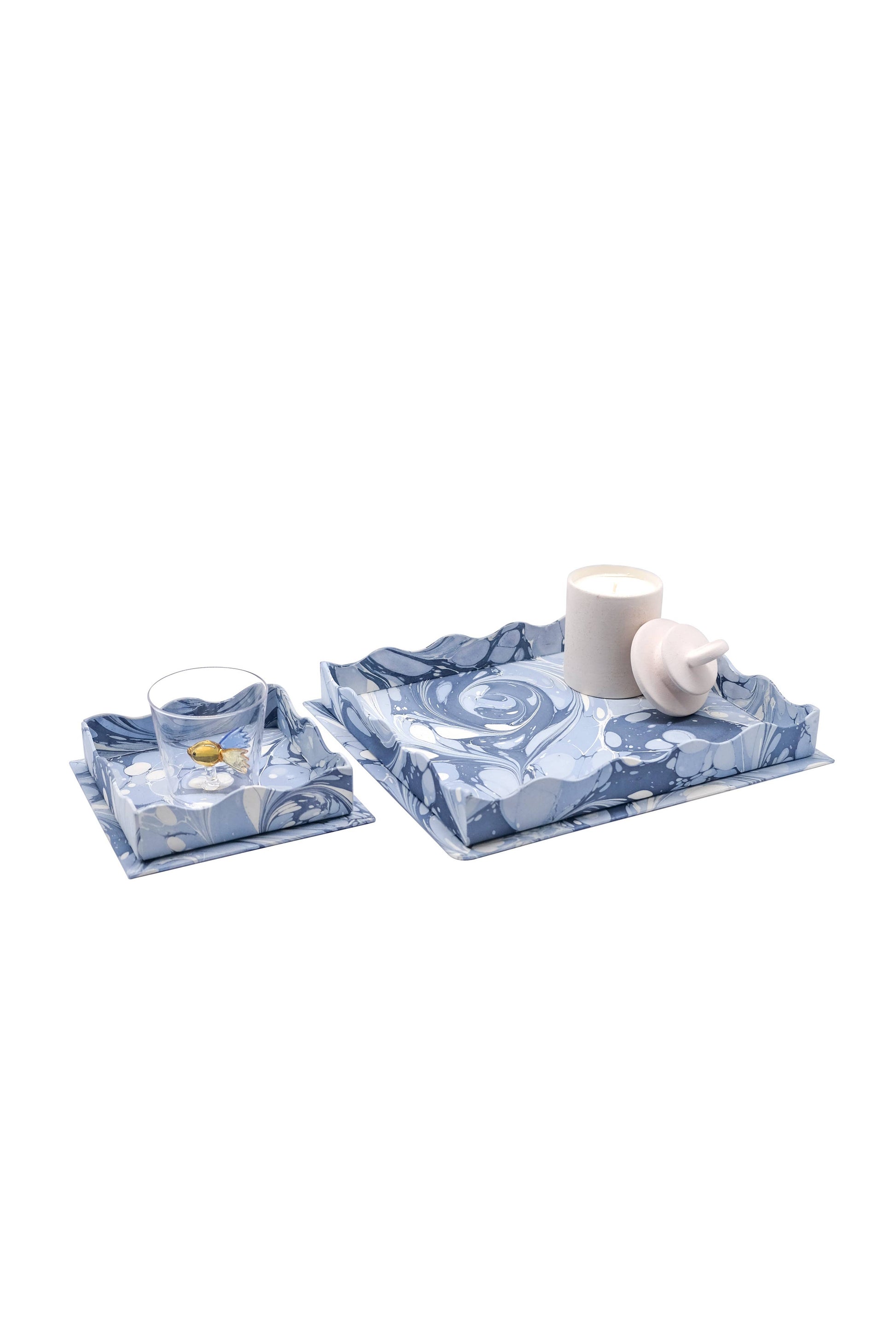Two blue patterned coasters with a white mug and glass on a white background