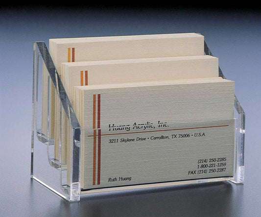 Clear acrylic business card holder displaying cream-colored business cards with orange vertical stripe accents and printed contact details.