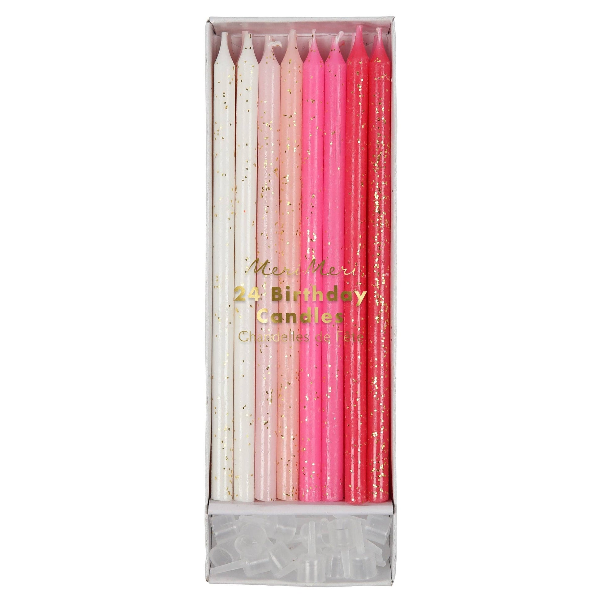 Set of birthday candles in pink, white, and gold packaging on a white background