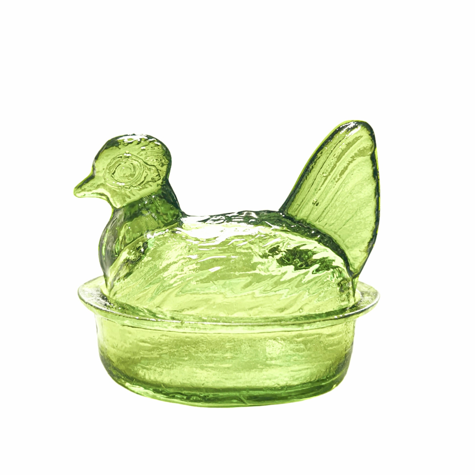 Green glass chicken-shaped container on a white background