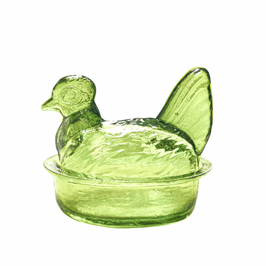Green glass chicken-shaped container on a white background