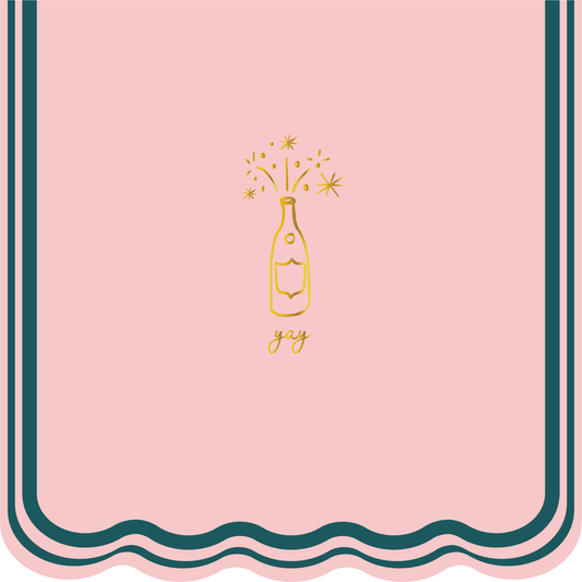 Pink napkin with gold champagne bottle and 'joy' text on a decorative border