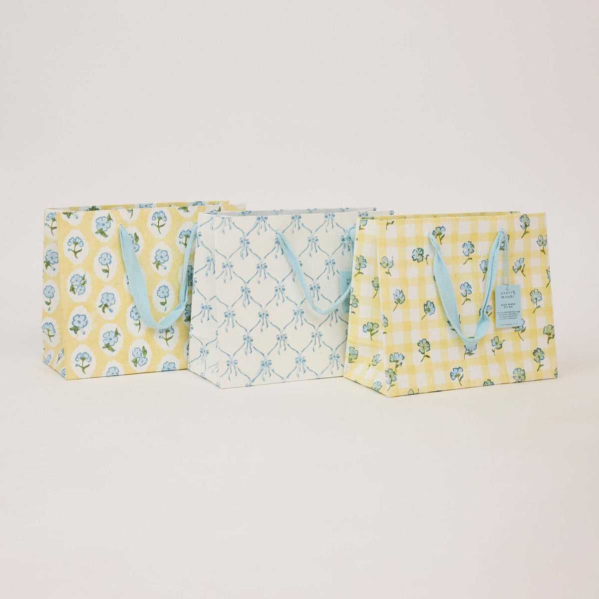 Three fabric bags with floral and checkered patterns on a light gray background