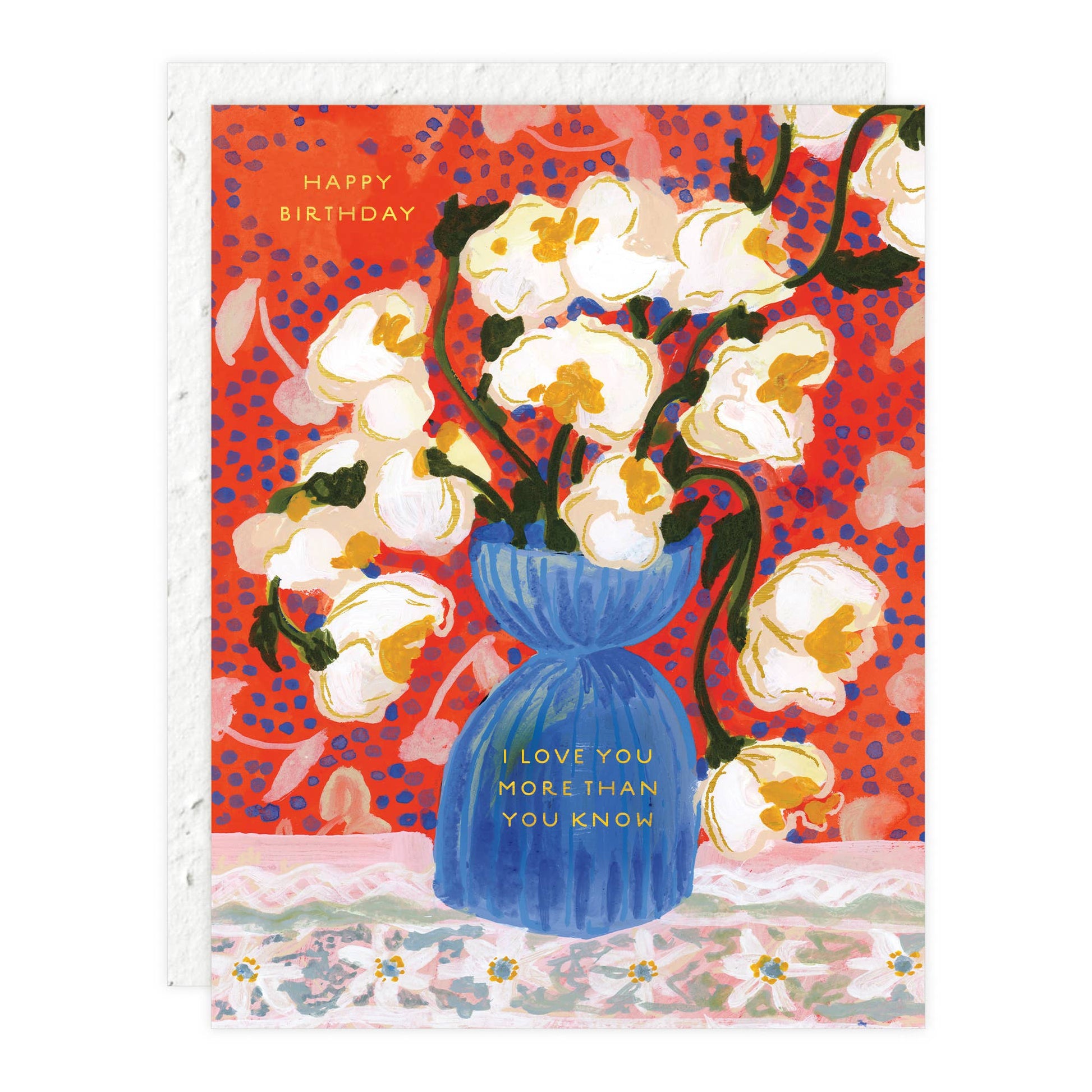 Birthday card with white flowers in a blue vase on a red and blue patterned background.