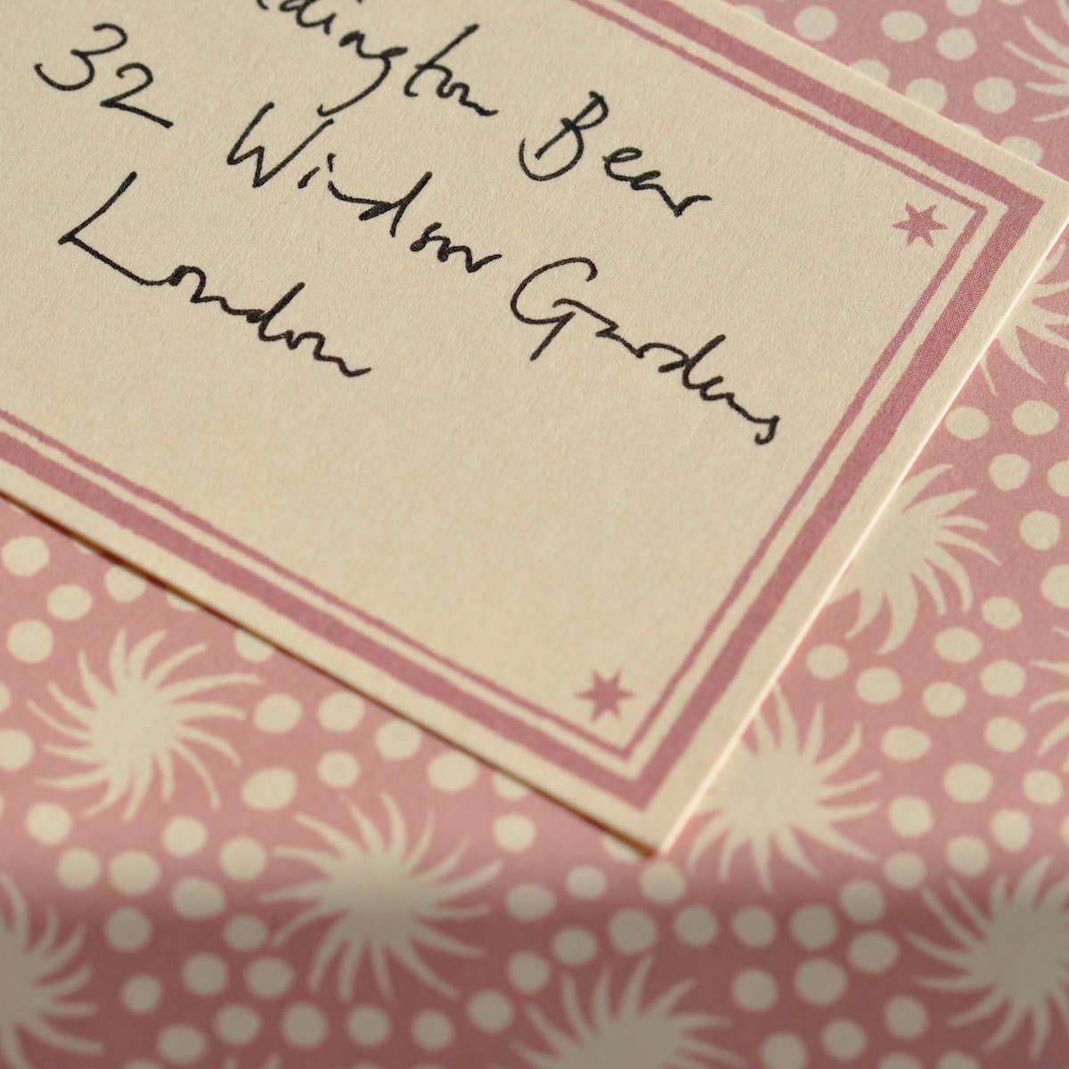 Close-up of a card with handwritten address on a pink polka dot background