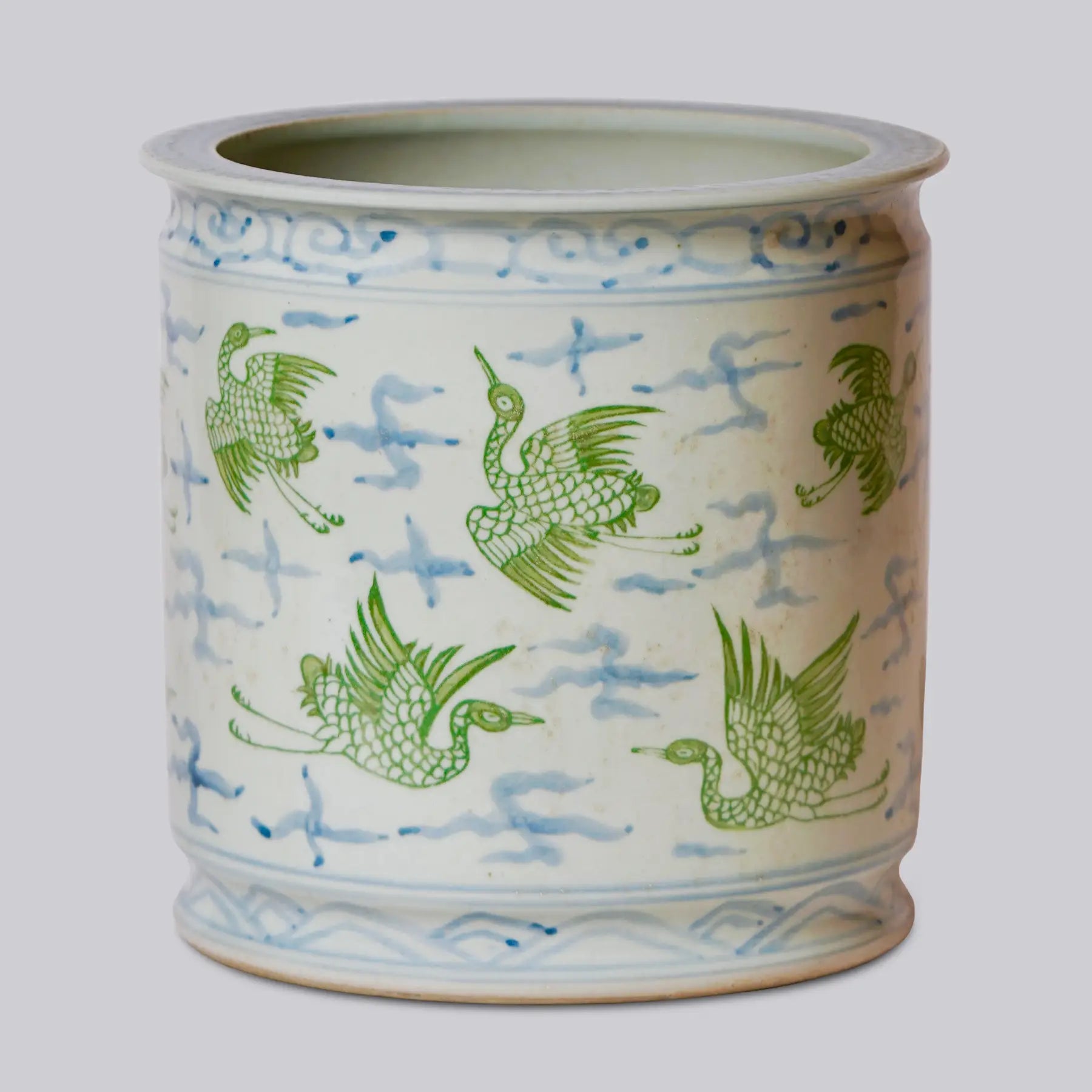 Ceramic vase with green bird designs on a white background