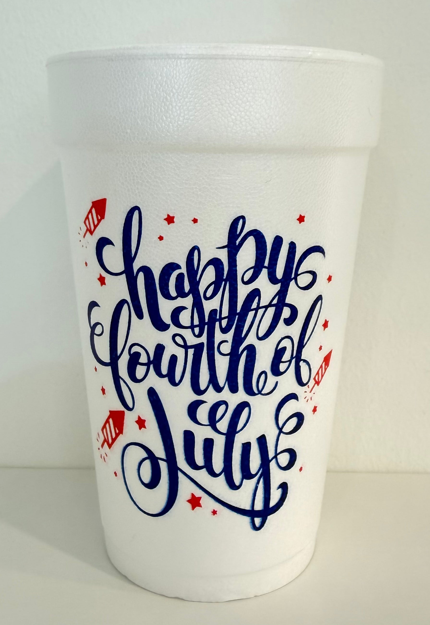 White styrofoam cups with 'Happy Fourth of July' text in blue 