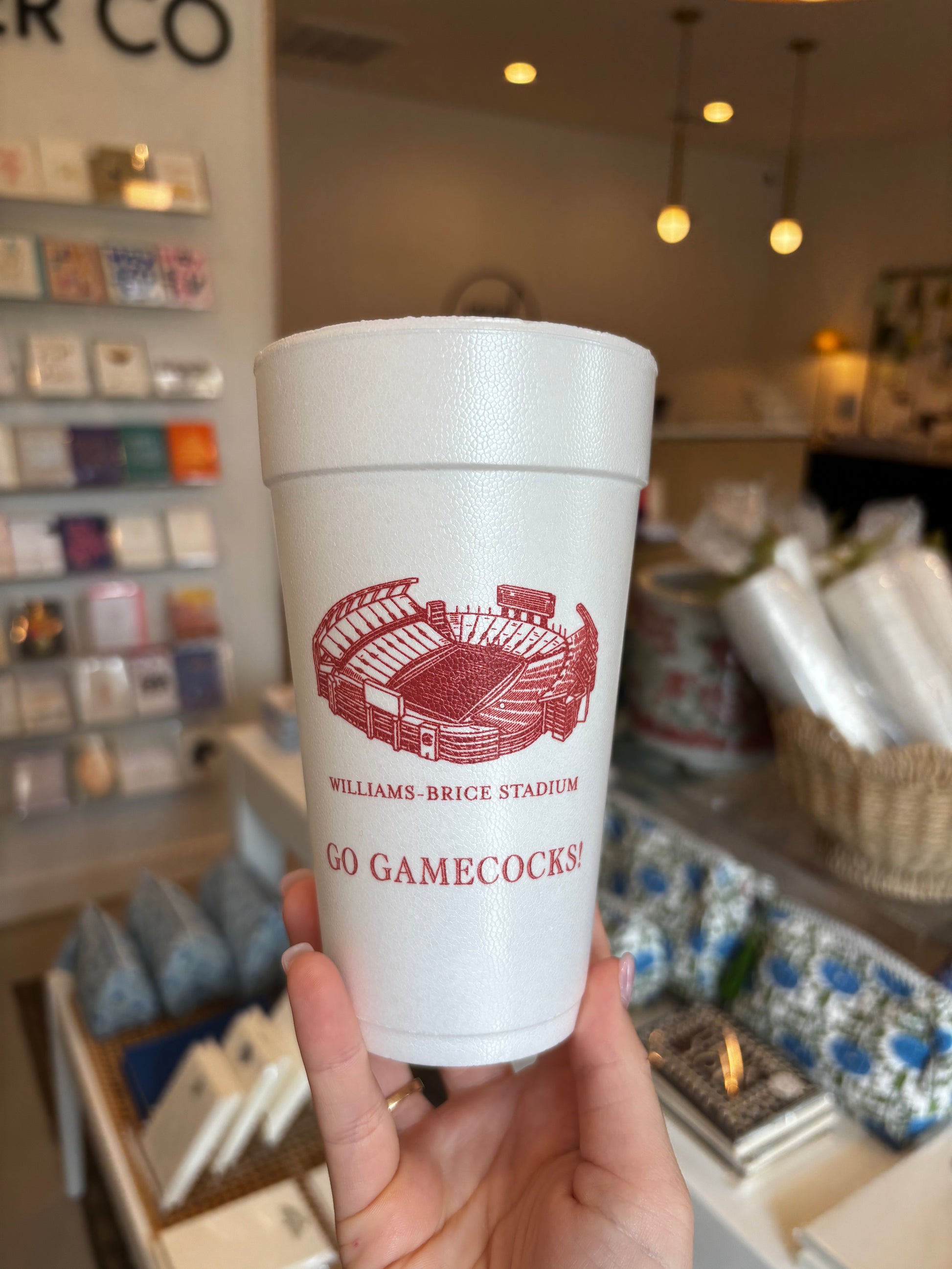 white foam cup printed with a red illustration of Williams-Brice Stadium and the text 'WILLIAMSBURG BRICE STADIUM' and 'GO GAMECOCKS' in a retail store setting.