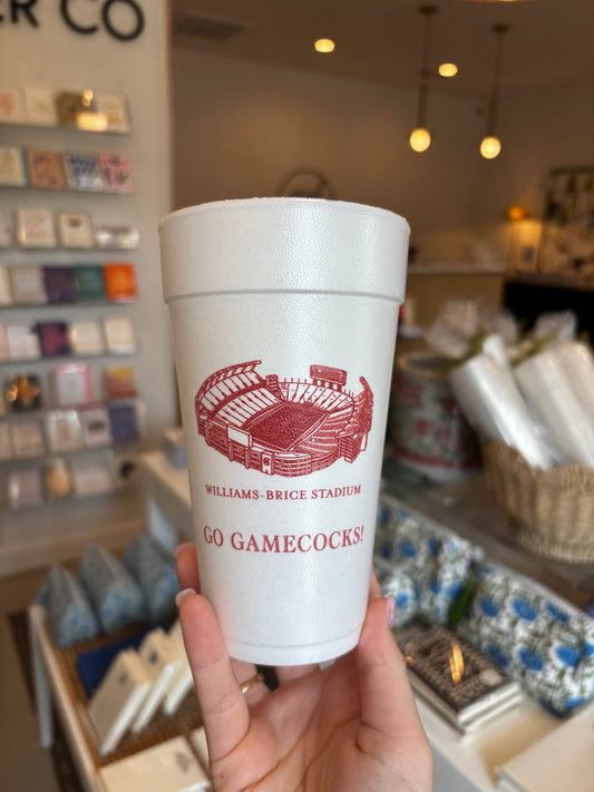 white foam cup printed with a red illustration of Williams-Brice Stadium and the text 'WILLIAMSBURG BRICE STADIUM' and 'GO GAMECOCKS' in a retail store setting.
