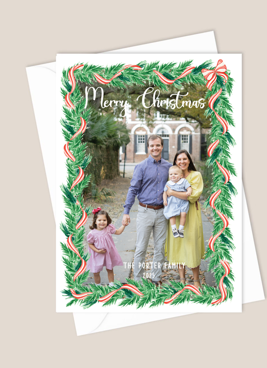 Christmas card with a family photo and festive border greenery with red and white ribbon
