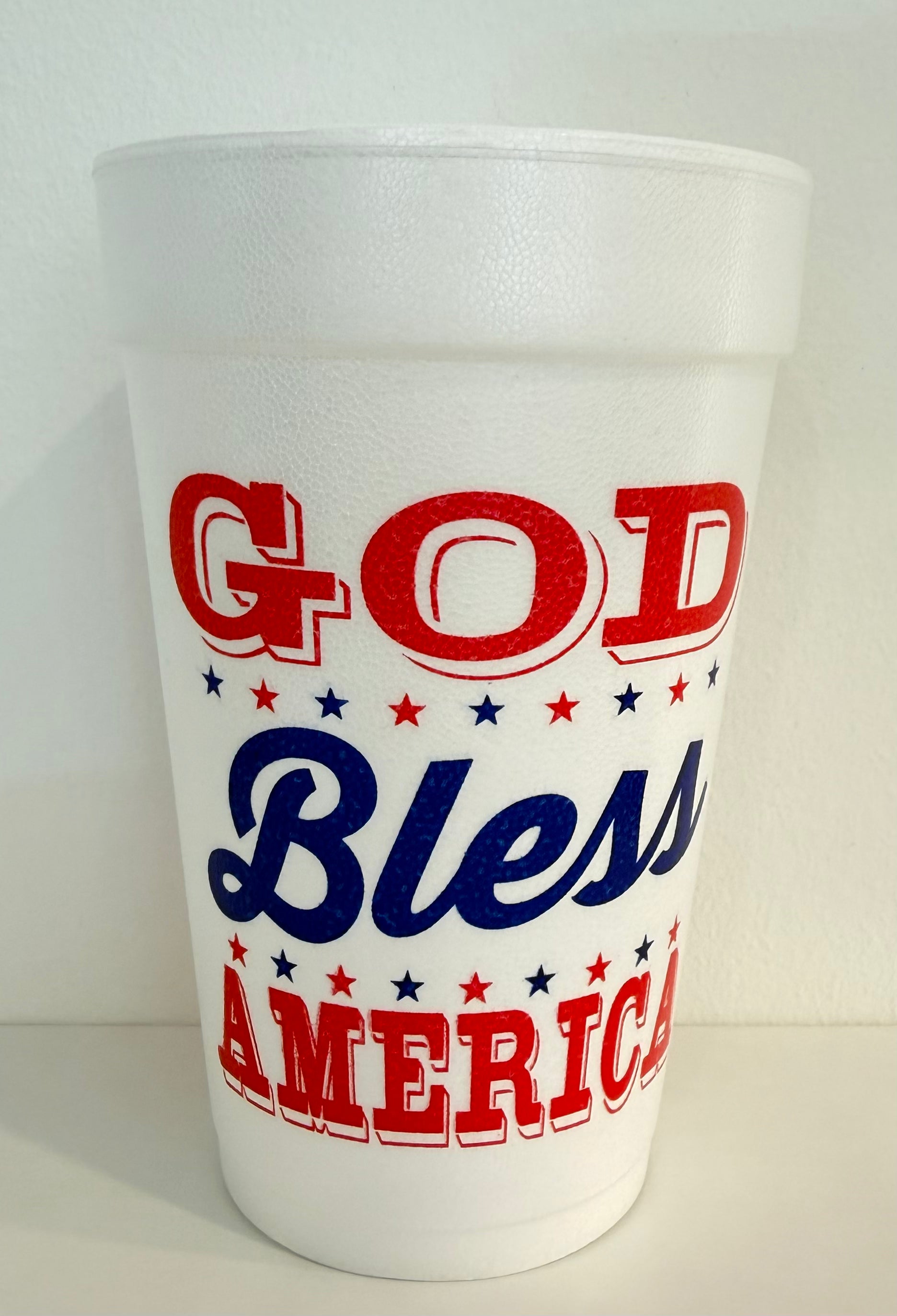 White foam cup with 'God Bless America' text in red and blue on a white background
