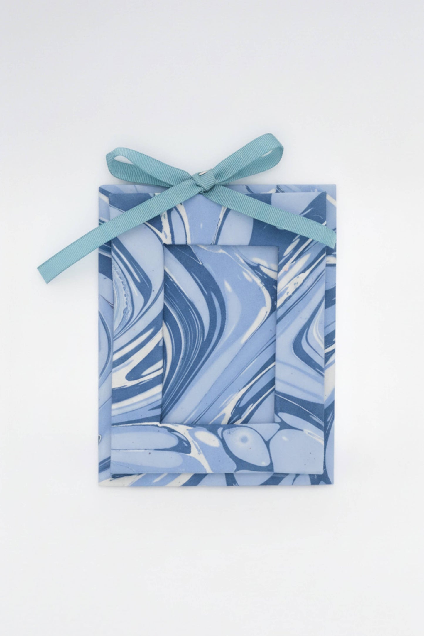 Marbled blue and white gift box with a ribbon on a white background