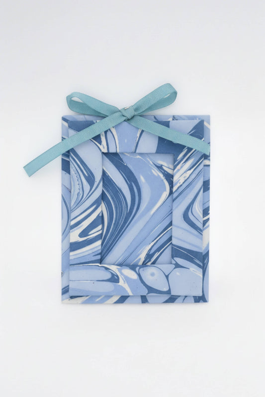 Marbled blue and white gift box with a ribbon on a white background