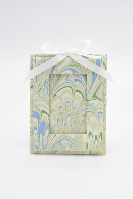 Gift box with marbled pattern and white ribbon on a white background