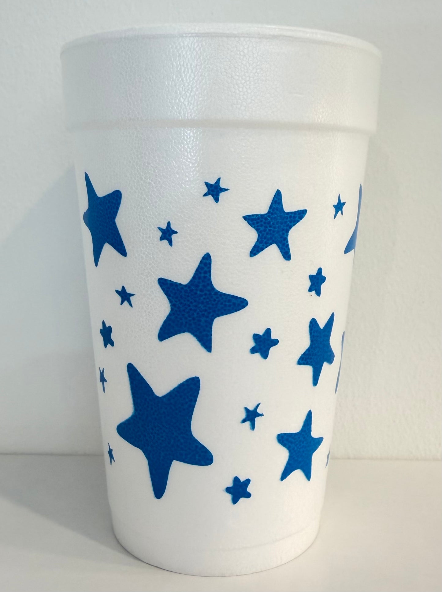 White tumbler with blue star patterns on a white background
