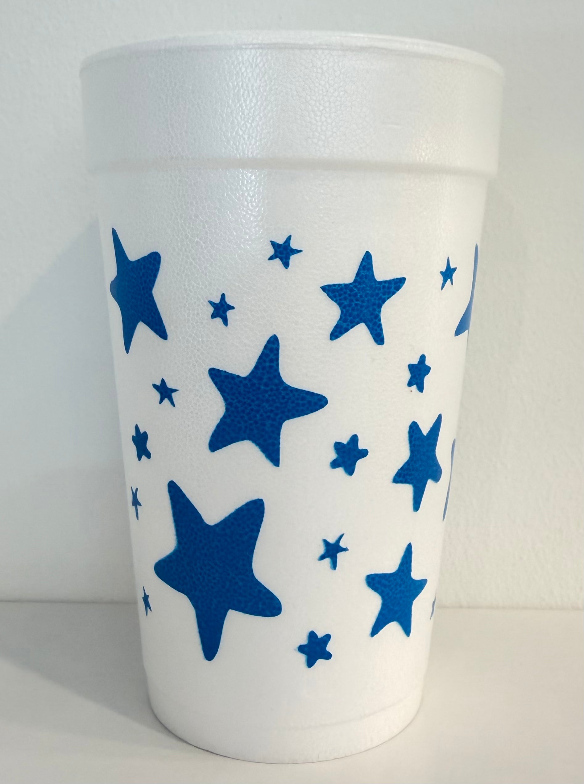 White tumbler with blue star patterns on a white background