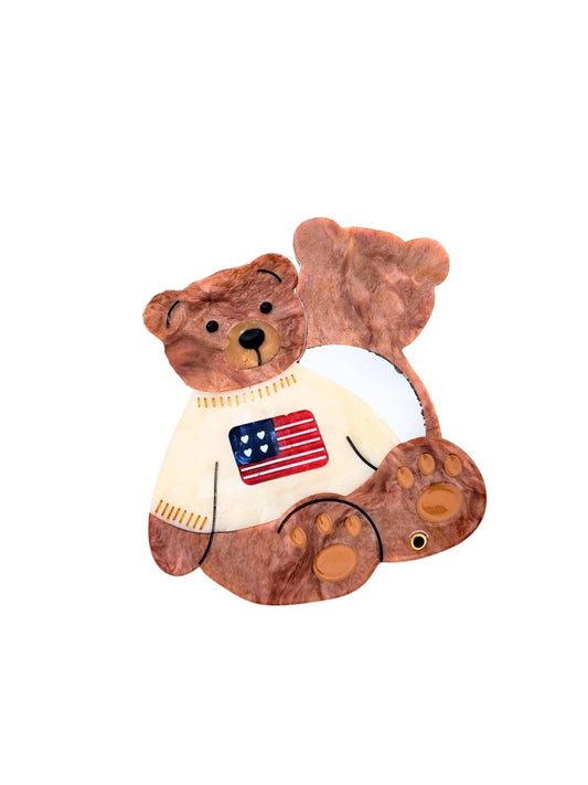 Teddy bear wearing a sweater with an American flag on a white background