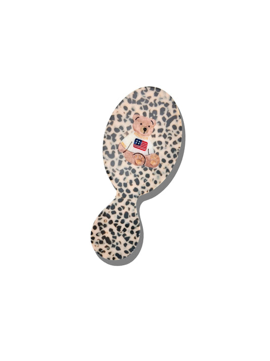 Leopard print hairbrush with a bear design on a white background